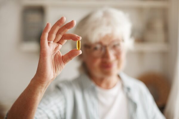 A person taking a vitamin B12 supplement to promote cardiovascular health