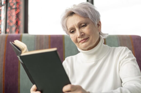 A senior woman reading a book to debunk myths about vitamin B12 and aging