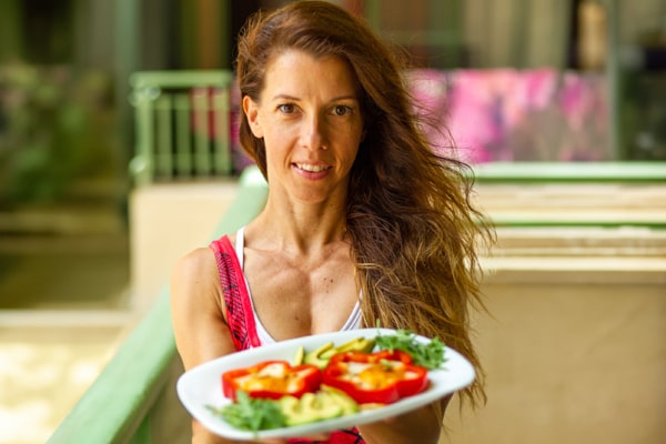 A captivating visual featuring a woman holding a bottle of collagen supplements in one hand and a plate of healthy food in the other. This image is used in the post titled 'Unlocking the Benefits of Collagen Weight Loss' by PatchMD - Vitamin Patches and Supplements. It serves as a representative visual element, emphasizing the potential benefits of collagen supplementation in combination with a healthy diet for weight loss. The photograph showcases the woman's engagement with both collagen supplements and nutritious food, encouraging readers to explore the advantages discussed in the post and consider incorporating collagen supplements into their weight loss journey alongside a balanced diet.