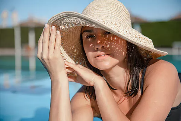 An illustrative image accompanying the 'What Happens When You Stop Taking Glutathione?' post by PatchMD - Vitamin Patches and Supplements, featuring a person wearing sunscreen and a hat to shield their skin from the sun.