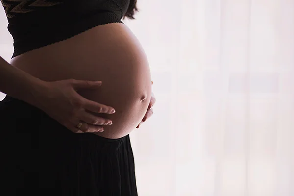 A woman taking melatonin supplements with a concerned expression Image of a woman with a concerned expression taking melatonin supplements, relevant to the blog post titled 'Can I Take Melatonin While Pregnant: Is It Safe?' by PatchMD - Vitamin Patches and Supplements.