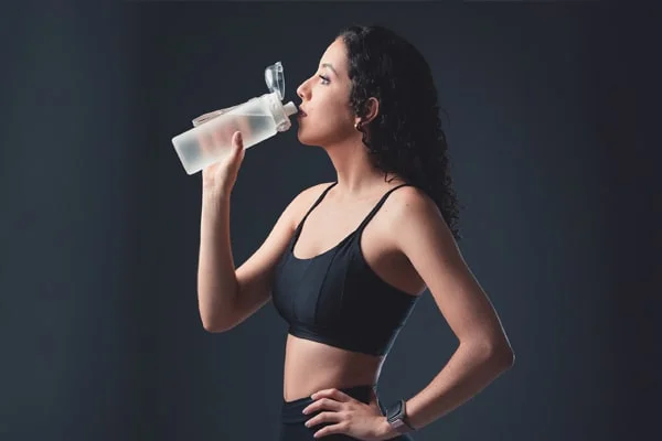 A captivating visual featuring a woman holding a glass of water with collagen powder from PatchMD - Vitamin Patches and Supplements. The image is used in the post titled 'Unlocking the Benefits of Collagen Weight Loss' by PatchMD. It showcases the potential benefits of collagen for weight loss and body composition improvement. The photograph highlights the woman's engagement with collagen powder, symbolizing its role in supporting weight management. It invites readers to explore the benefits discussed in the post and consider incorporating collagen supplements into their weight loss journey.