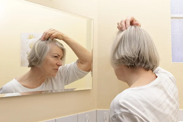 Image for 'How to Reverse Thinning Hair After Menopause - An Expert Guide' post by PatchMD - Vitamin Patches and Supplements, showcasing a woman with thinning hair, determined to reverse it, in line with the topic of the article