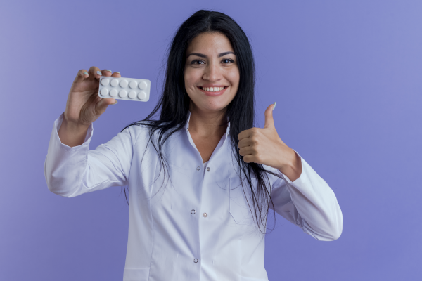 A person holding a bottle of magnesium supplement with a label showing the health benefits