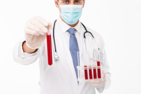 A person holding a test tube with a sample of blood for a magnesium test