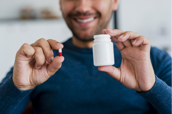 A person holding a bottle of dietary supplements