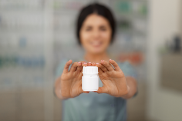 A person holding a bottle of magnesium supplement with a label showing the daily magnesium requirements