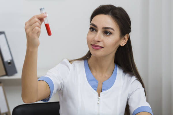 A person holding a test tube with a sample of blood for a magnesium test